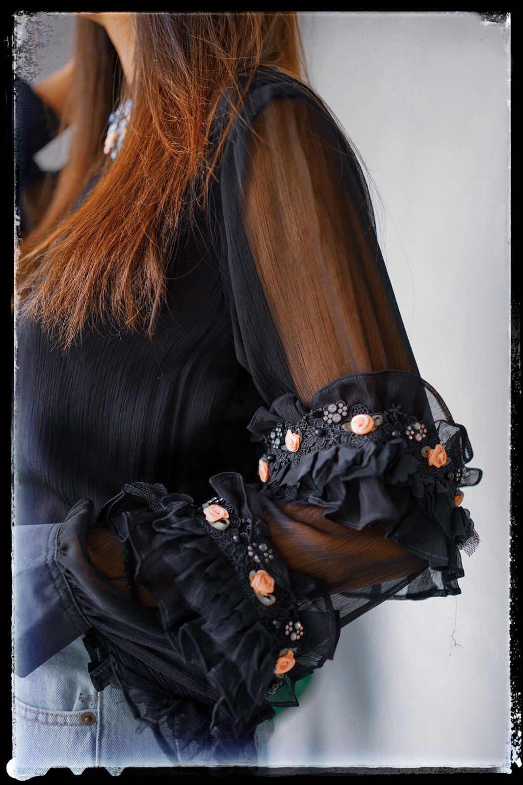 Black chiffon top designed with frill and buttons.
